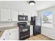 Bright kitchen features white cabinets, granite countertops and black appliances at 9424 Lexington Cir # F, Charlotte, NC 28213