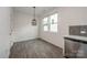 Open dining area with modern lighting, stainless steel dishwasher, and wood-look flooring at 13047 Gadwal Pintail Dr, Charlotte, NC 28262