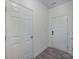 Clean hallway with gray wood-look floors, white doors, and neutral walls at 13047 Gadwal Pintail Dr, Charlotte, NC 28262