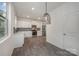 Modern kitchen with white cabinetry, stainless steel appliances, and stylish pendant lighting at 13047 Gadwal Pintail Dr, Charlotte, NC 28262