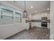 Well-lit kitchen with stainless steel appliances, white cabinets, and modern light fixture at 13047 Gadwal Pintail Dr, Charlotte, NC 28262