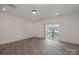 Living room showcasing wood-look floors, recessed lighting, and sliding glass doors to the balcony at 13047 Gadwal Pintail Dr, Charlotte, NC 28262