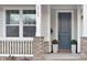 Inviting front porch with brick columns, a gray door, and potted plants at 2304 Catalina Ave, Charlotte, NC 28206