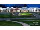 A beautifully landscaped view of the clubhouse featuring well-manicured greenery and a pathway at 6296 Raven Rock Dr # 725, Denver, NC 28037