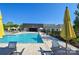 A community pool with lounge seating, tables, umbrellas, and nearby community buildings at 6296 Raven Rock Dr # 725, Denver, NC 28037