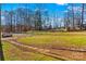 Front yard with stone pathway, grassy area, and a wooded backdrop at 797 Chief Thomas Rd, Harmony, NC 28634