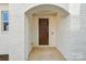 Inviting entryway featuring a classic wood door, brick walls, and a charming arched entrance at 817 Terra Dr, Tega Cay, SC 29708