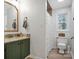 Well-lit bathroom with a green vanity, decorative mirror, and patterned shower curtain at 914 Wyke Rd, Shelby, NC 28150