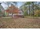 Spacious backyard with scattered leaves and wood fence bordering an exterior view of the home at 914 Wyke Rd, Shelby, NC 28150