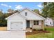 Charming white farmhouse style home with a blue door and landscaped yard at 2443 Myrtle Ave, Gastonia, NC 28052