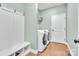 Functional laundry room with white washer, dryer, storage, bench, and tiled floor at 360 Lauren Pines Dr, York, SC 29745