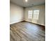 Bright bedroom with wood-look flooring and two large windows at 723 E Memorial Hwy, Harmony, NC 28634