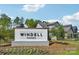 Windell Woods community entrance sign with landscaped surroundings under a blue sky with some clouds at 809 Terra Dr, Tega Cay, SC 29708