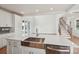 Modern kitchen island with a stainless steel sink, white cabinets, and views of the living area at 809 Terra Dr, Tega Cay, SC 29708