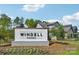 Windell Woods community sign nestled in a landscaped area with trees and newer style homes in the background at 821 Terra Dr, Tega Cay, SC 29708