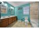 Teal bathroom with double vanity and bathtub shower combo at 6934 Spring Morning Ln, Charlotte, NC 28227