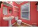 Coral-colored bathroom with pedestal sink and tile flooring at 6934 Spring Morning Ln, Charlotte, NC 28227