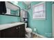 Teal bathroom with single vanity and updated toilet at 6934 Spring Morning Ln, Charlotte, NC 28227