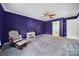 Bright bedroom with purple walls, ceiling fan, and access to bathroom at 6934 Spring Morning Ln, Charlotte, NC 28227