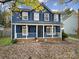 Two-story blue house with white trim, porch, and landscaping at 6934 Spring Morning Ln, Charlotte, NC 28227