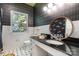 Bathroom featuring a black countertop, an oval mirror and patterned wall paper at 70 Spring Nw St, Concord, NC 28025