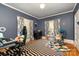 This bedroom is decorated with blue walls, hardwood floors and natural light at 70 Spring Nw St, Concord, NC 28025