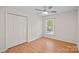 Bright bedroom featuring hardwood floors and a double door closet at 12017 Baywoods Dr, Tega Cay, SC 29708