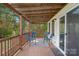 Covered deck with wooden railing, seating and view of nature at 12017 Baywoods Dr, Tega Cay, SC 29708