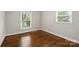 Well-lit bedroom featuring hardwood floors and two windows at 1915 Wedgedale Dr, Charlotte, NC 28210