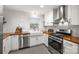 Modern white kitchen with stainless steel appliances and a wood countertop at 1915 Wedgedale Dr, Charlotte, NC 28210