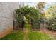 Landscaped backyard with an archway and wrought iron gate at 6941 Augustine Way, Charlotte, NC 28270