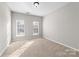 Bright bedroom with neutral walls and carpet, featuring two windows at 6941 Augustine Way, Charlotte, NC 28270