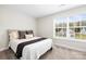 This sun-filled bedroom boasts a comfy queen bed, neutral colors, and a window overlooking the home's exterior at 159 Tanner Loop, Troutman, NC 28166
