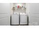 Bright laundry room features a side-by-side washer and dryer, with storage shelves above, and white paneled doors at 159 Tanner Loop, Troutman, NC 28166