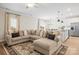 Open living room with a comfortable sectional sofa, pendant lighting, and seamless flow to the kitchen at 159 Tanner Loop, Troutman, NC 28166
