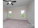 Bedroom features neutral carpet, two windows that provide natural light, and a ceiling fan at 3034 Buffet Ln, Monroe, NC 28110