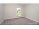 Cozy bedroom with neutral carpet, a large window, and a view of the outdoors at 3034 Buffet Ln, Monroe, NC 28110