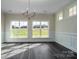 Formal dining room with classic wainscoting, a chandelier, large windows, and dark wood floors offering serene views at 3034 Buffet Ln, Monroe, NC 28110
