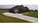 Long concrete driveway leading to a brick home with a two-car garage and well-maintained landscaping at 3034 Buffet Ln, Monroe, NC 28110