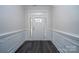 Welcoming entryway with classic paneled walls, dark hardwood flooring, and a white front door with sidelights at 3034 Buffet Ln, Monroe, NC 28110