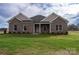 Charming brick home with a well-manicured lawn and a covered front porch with white columns and light landscaping at 3034 Buffet Ln, Monroe, NC 28110