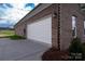 Attached two-car garage with a white door, complementing the home's exterior and landscaping at 3034 Buffet Ln, Monroe, NC 28110