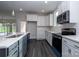 Stylish kitchen with a large island, white cabinets, stainless steel appliances, and dark wood floors for a sleek design at 3034 Buffet Ln, Monroe, NC 28110