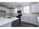 Well-lit kitchen with white cabinets, stainless steel appliances, a kitchen island, and hardwood floors, perfect for home cooking at 3034 Buffet Ln, Monroe, NC 28110
