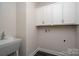 Well-equipped laundry room with a sink, white cabinets, and connections for a washer and dryer at 3034 Buffet Ln, Monroe, NC 28110