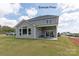 Gray house with a covered patio and seating area, overlooking a manicured lawn at 1017 Wandsworth Pl # Ken0108, Charlotte, NC 28215