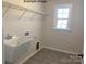 Laundry room with utility sink, tile floor, and shelving at 1017 Wandsworth Pl # Ken0108, Charlotte, NC 28215