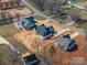 Aerial view of a home under construction with an outdoor living space in a wooded area at 229 Golf Course Rd, Maiden, NC 28650