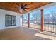 A large covered back porch with wood flooring, stained wood beams, and an outdoor ceiling fan at 229 Golf Course Rd, Maiden, NC 28650