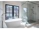 A bright bathroom featuring a glass shower, modern tub, and large window at 229 Golf Course Rd, Maiden, NC 28650